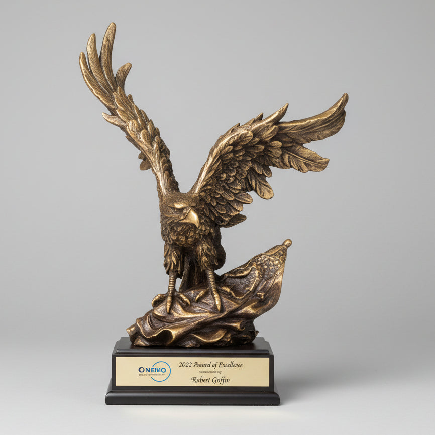 Bronze eagle sculpture on a wooden stump with mountains in the background
