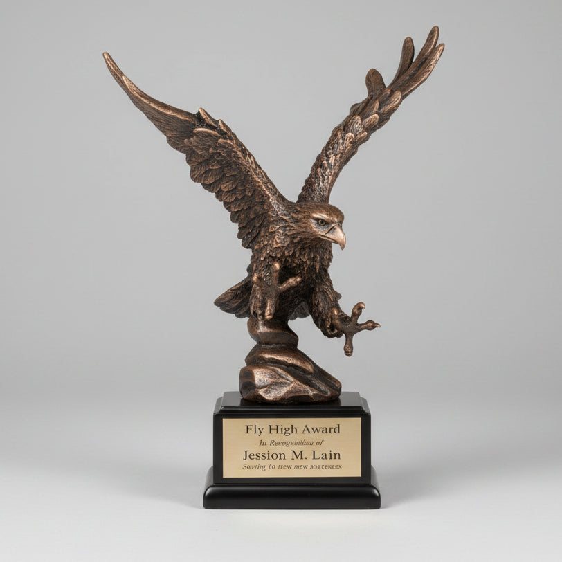 Bronze eagle sculpture on a wooden stump with mountains in the background